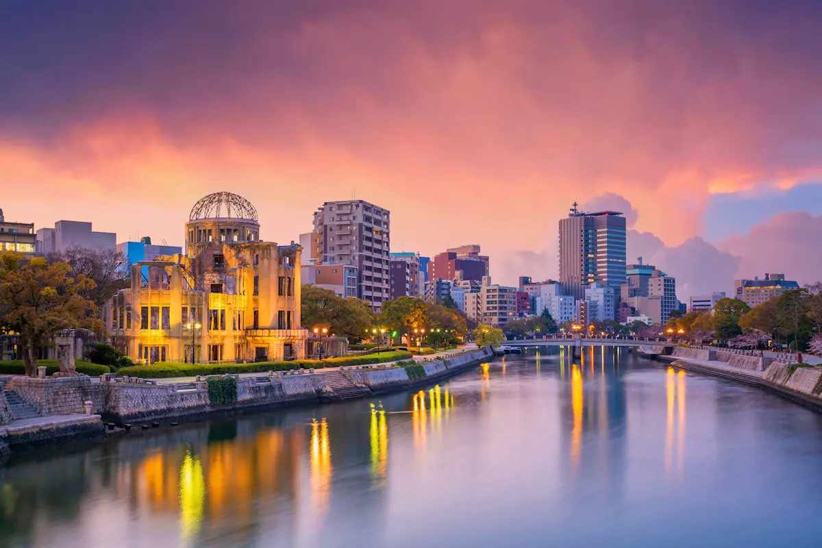 Hiroshima skyline at dusk showing the Atomic Dome lit up in the foreground