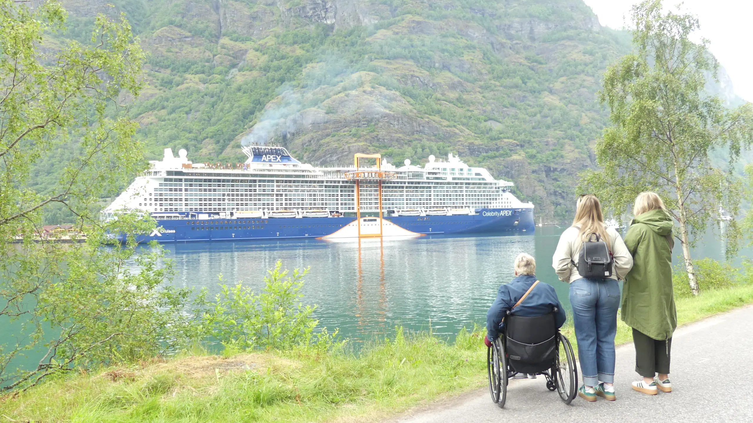 Image shows three women looking across a Norwegian fjord at the Celebrity Apex