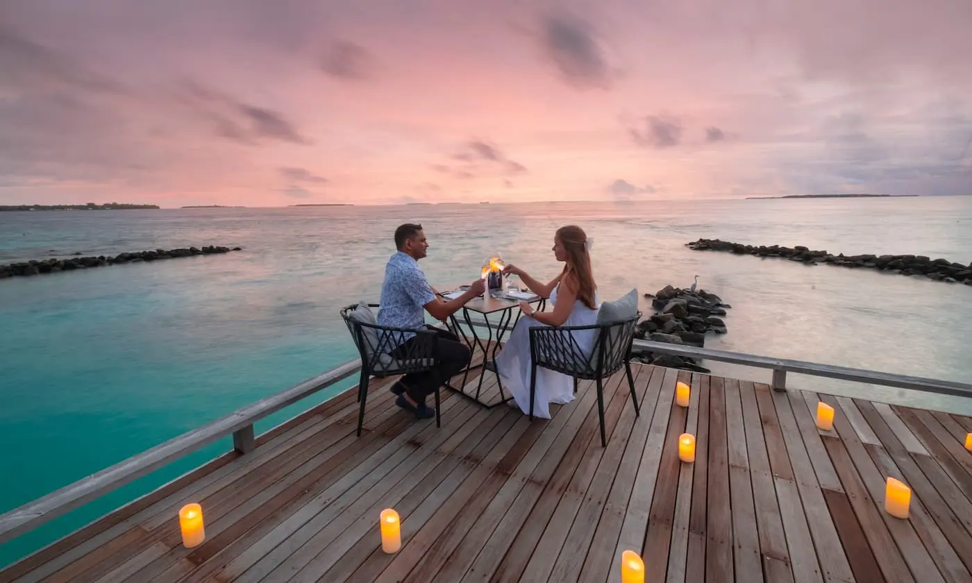 A couple dining whilst overlooking the ocean at Amilla maldives