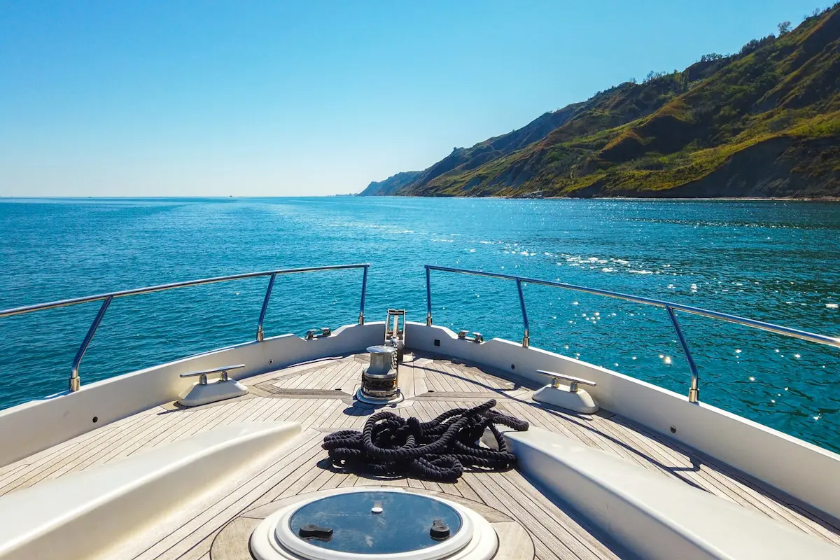 Image of the bow of a luxury yacht looking out over the blue ocean